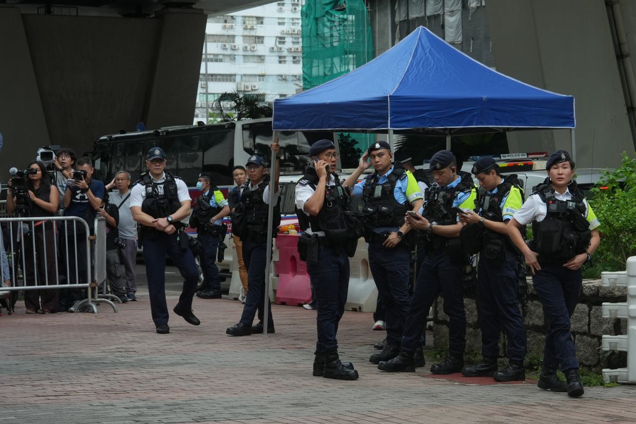 Hong Kong woman arrested for seditious T-shirt outside court as democracy leaders convicted